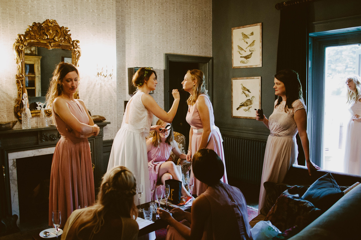 bride putting make up on bridesmaid