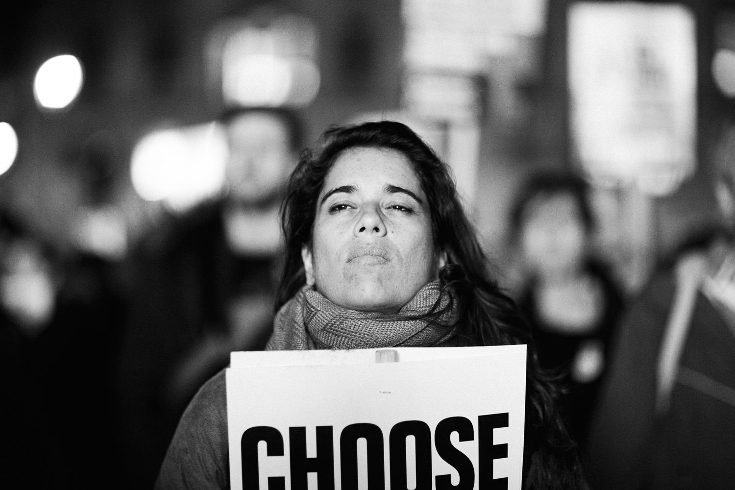 woman holding sign saying "choose life" at Trump protest