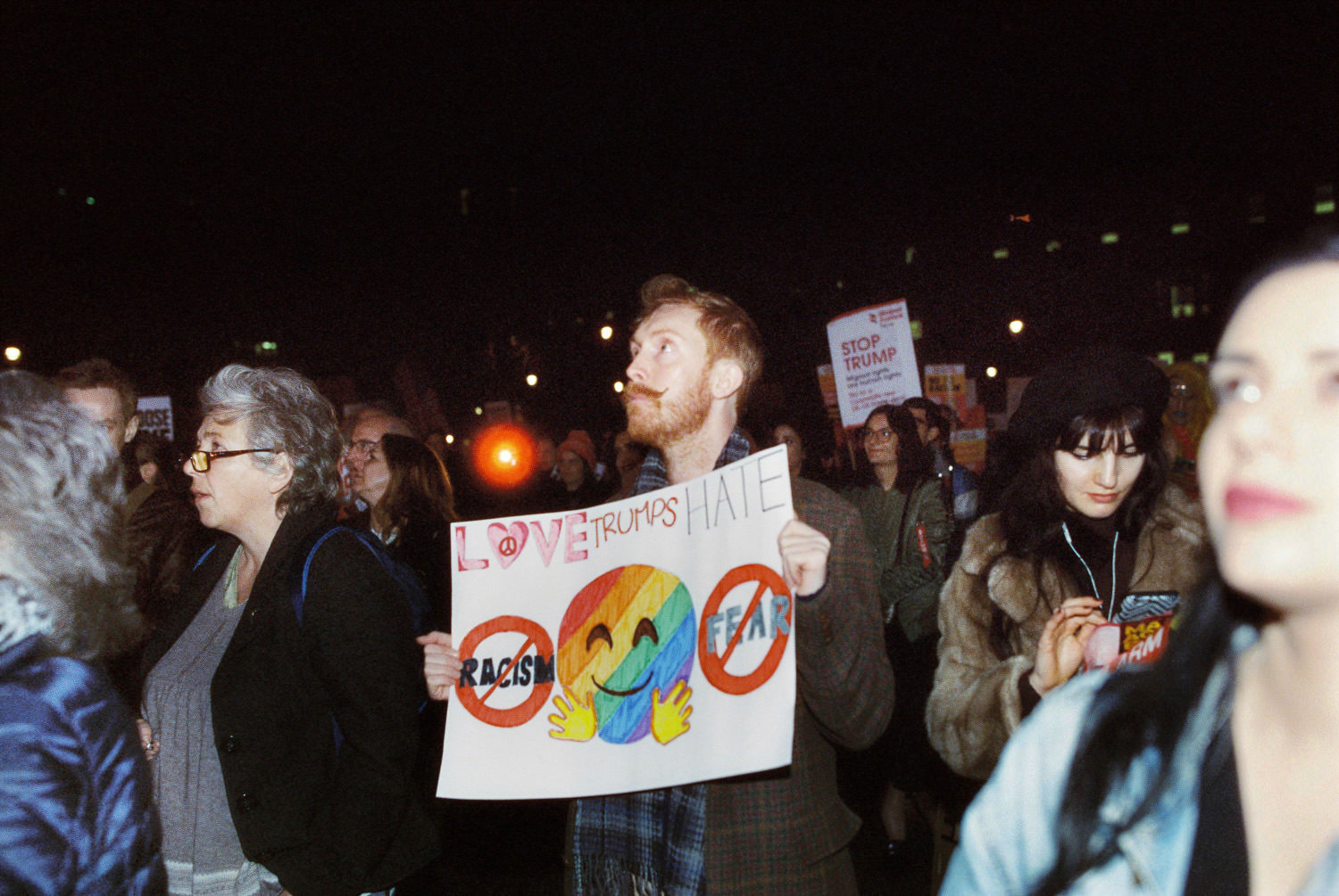 man with big moustache holding placard at Trump demonstration