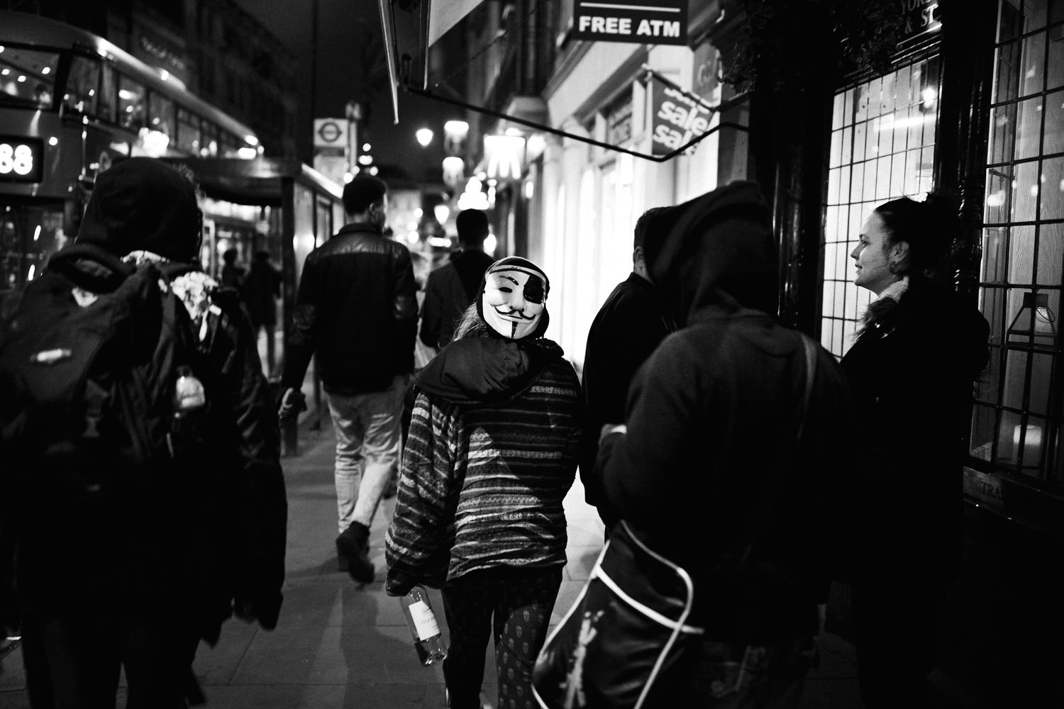 teenager wearing Guy Fawkes mask on London street