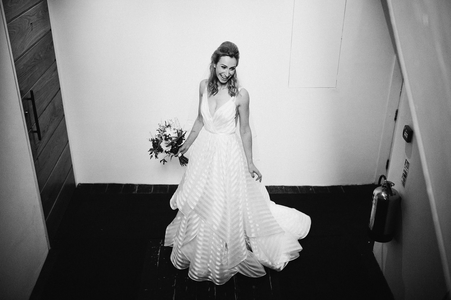 Bride laughing on stairwell of hotel