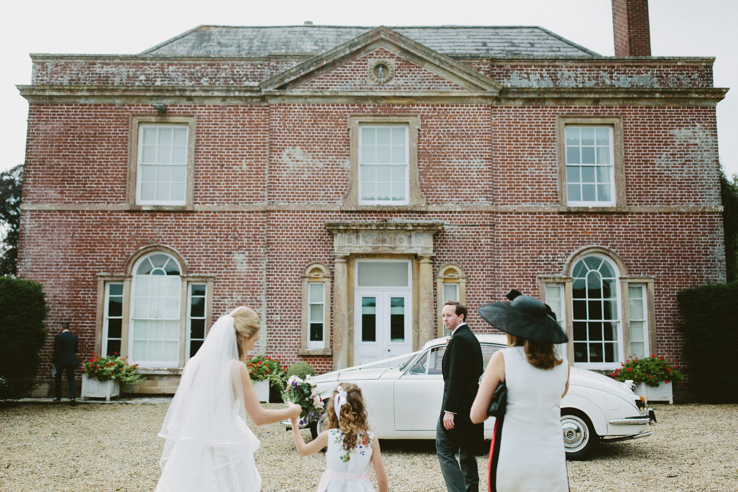 Bride and groom walking in front of Yarlington house 