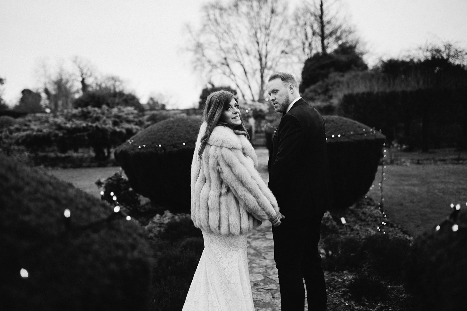 bride and groom walk in gardens at Barnsley House