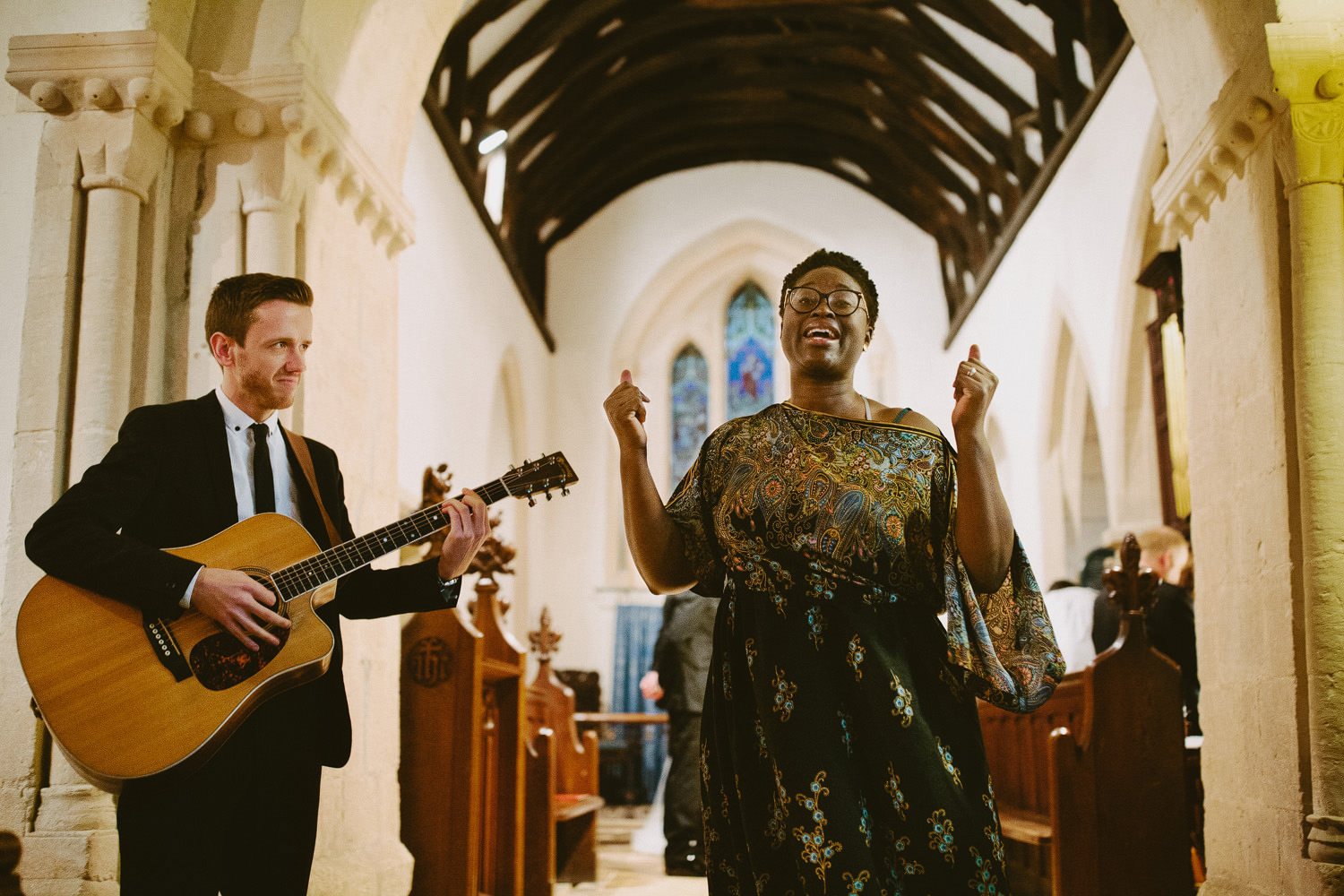 soul singer singing in church with guitarist beside her