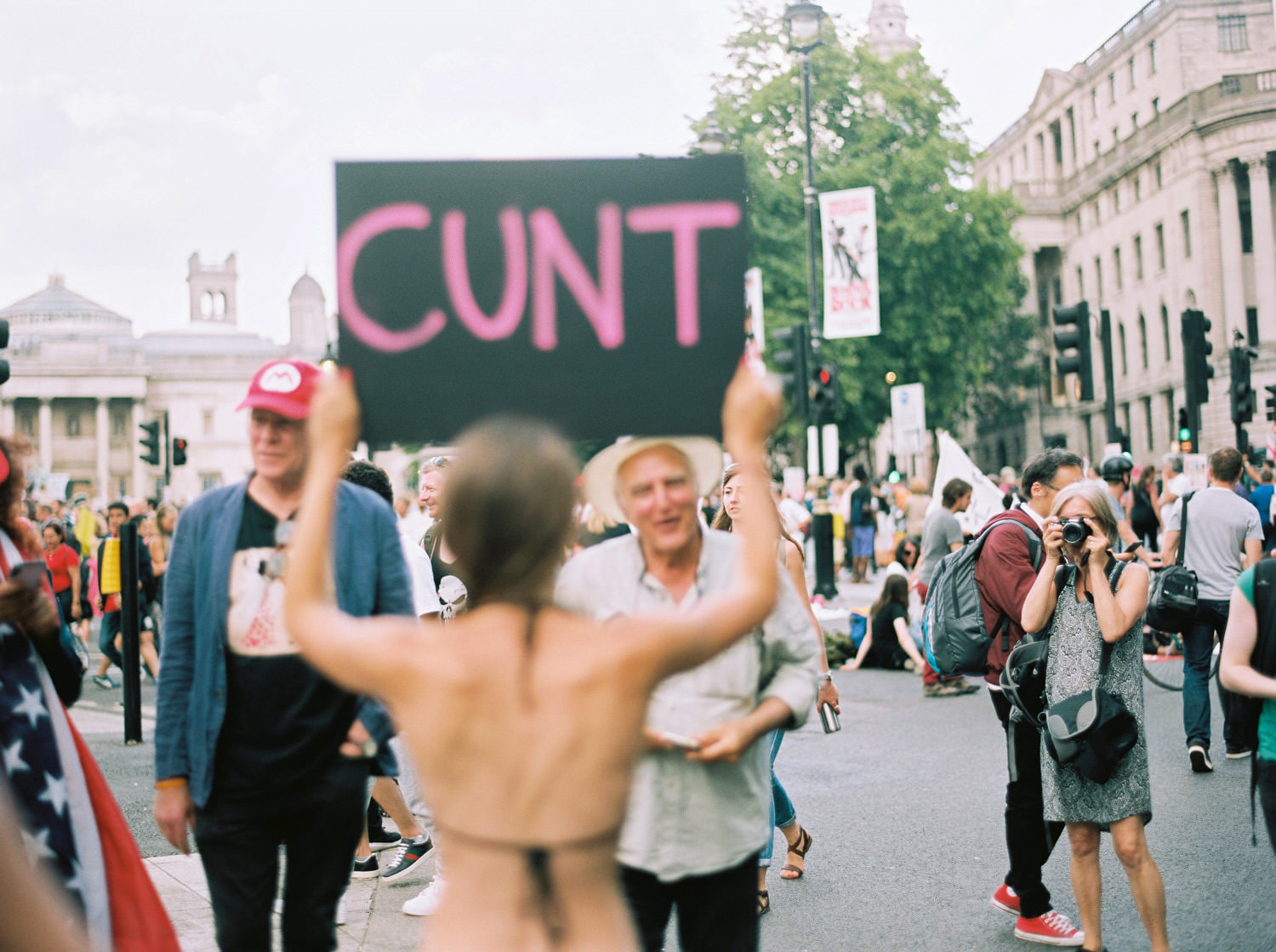 lady holding placard reading "cunt" at London protest