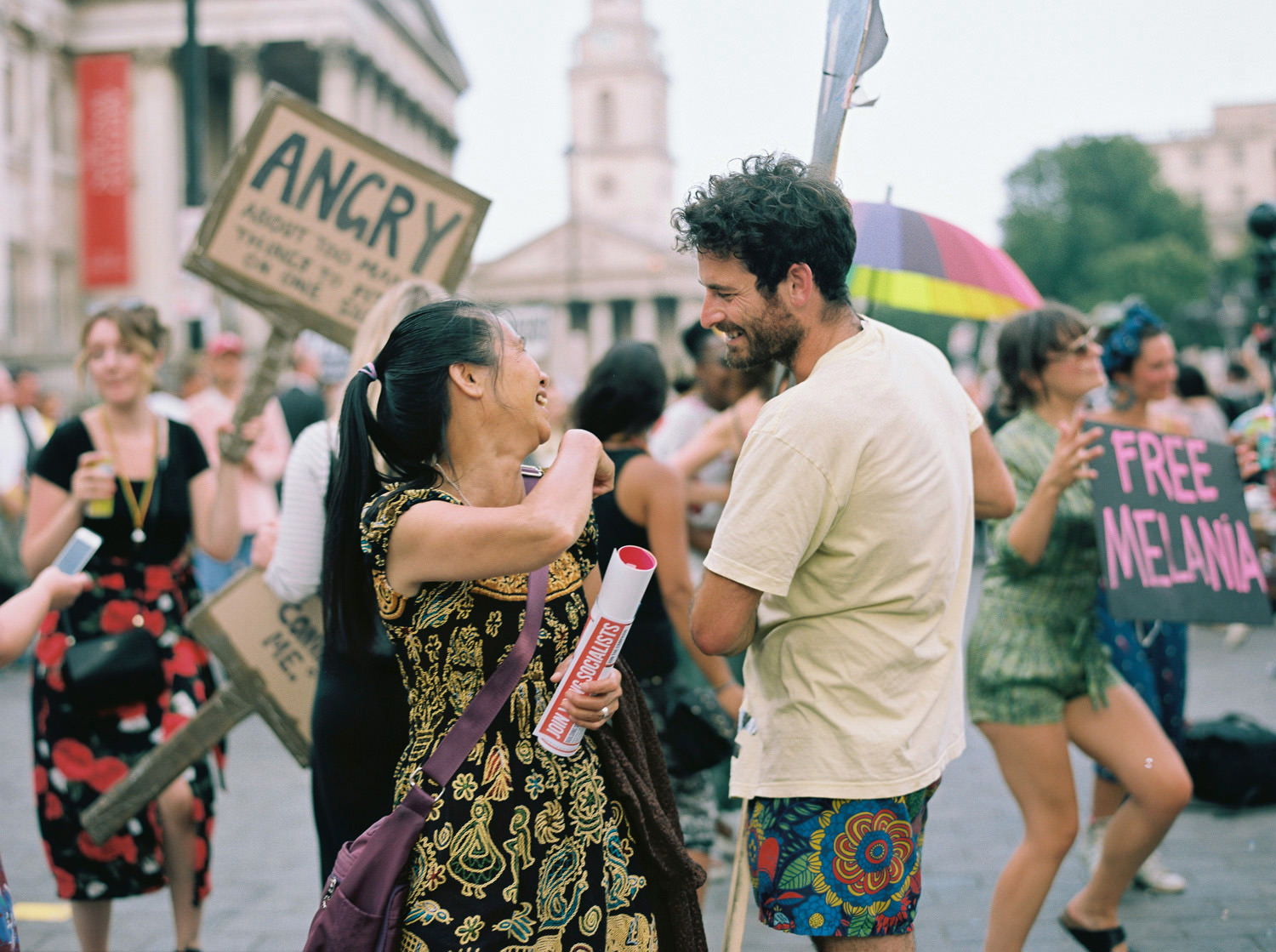 woman and man share a laugh at London protest against President Trump visit