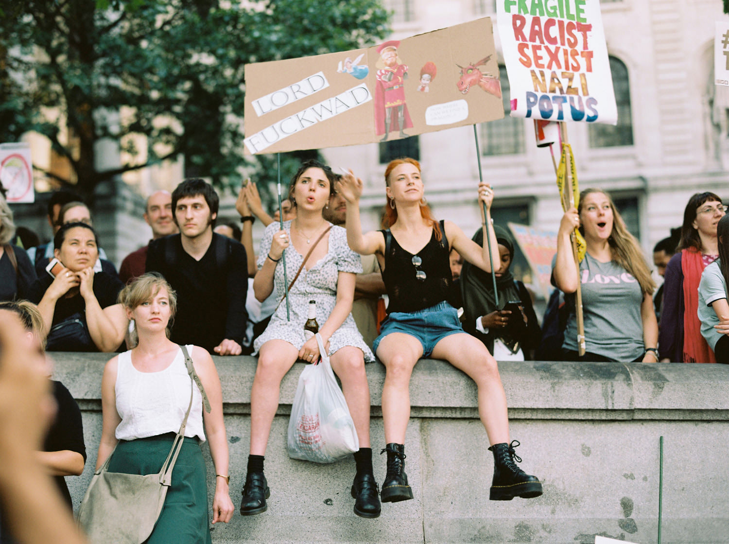 protestors at anti-Trump rally sat on wall in Trafalgar Square