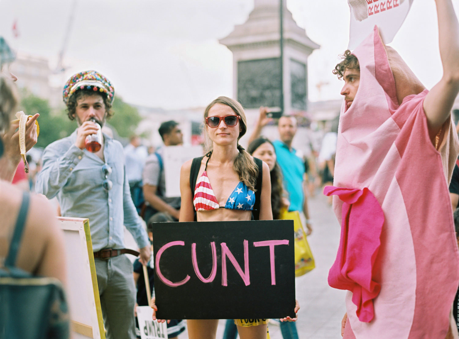 girl holding "cunt" placard at trafalgar square Trump protest