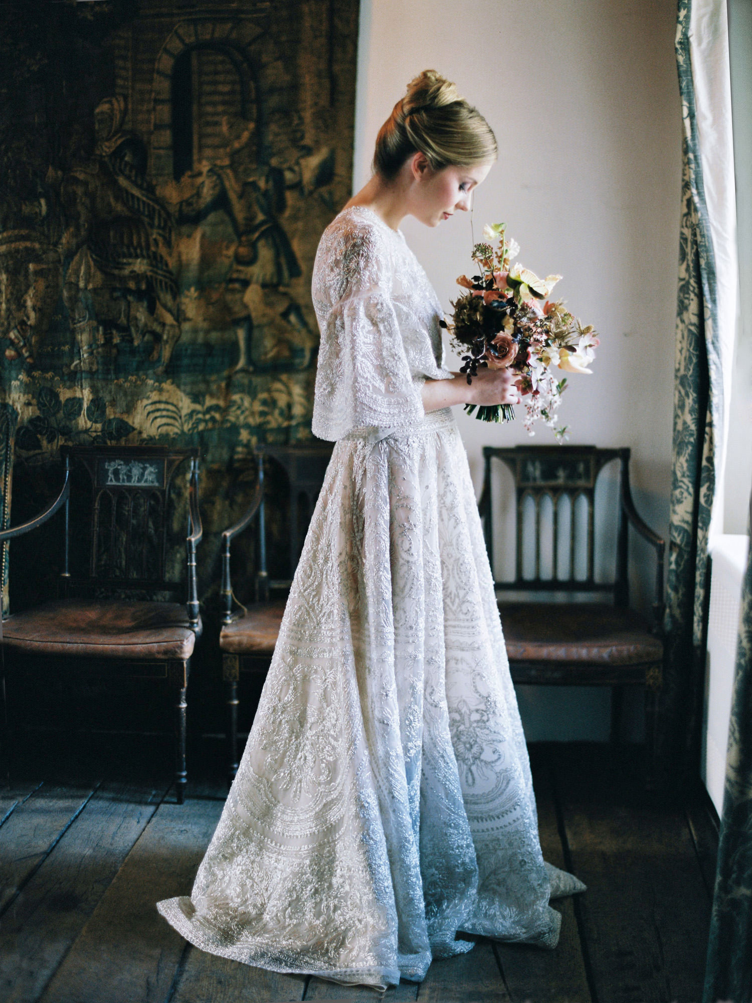 bride smelling her bouquet wearing naeem khan dress