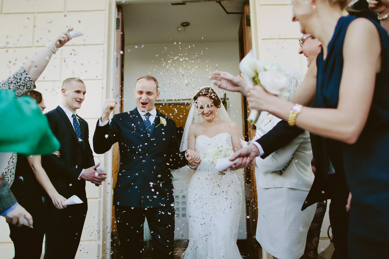 Bride and groom leave the ICA after their wedding while guests throw confetti