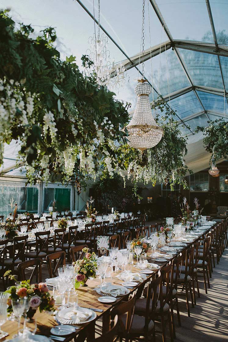 wedding tables with greenery hanging above