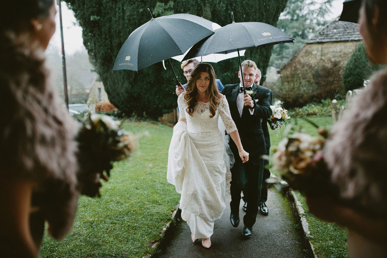 bride arriving at church with umbrellas