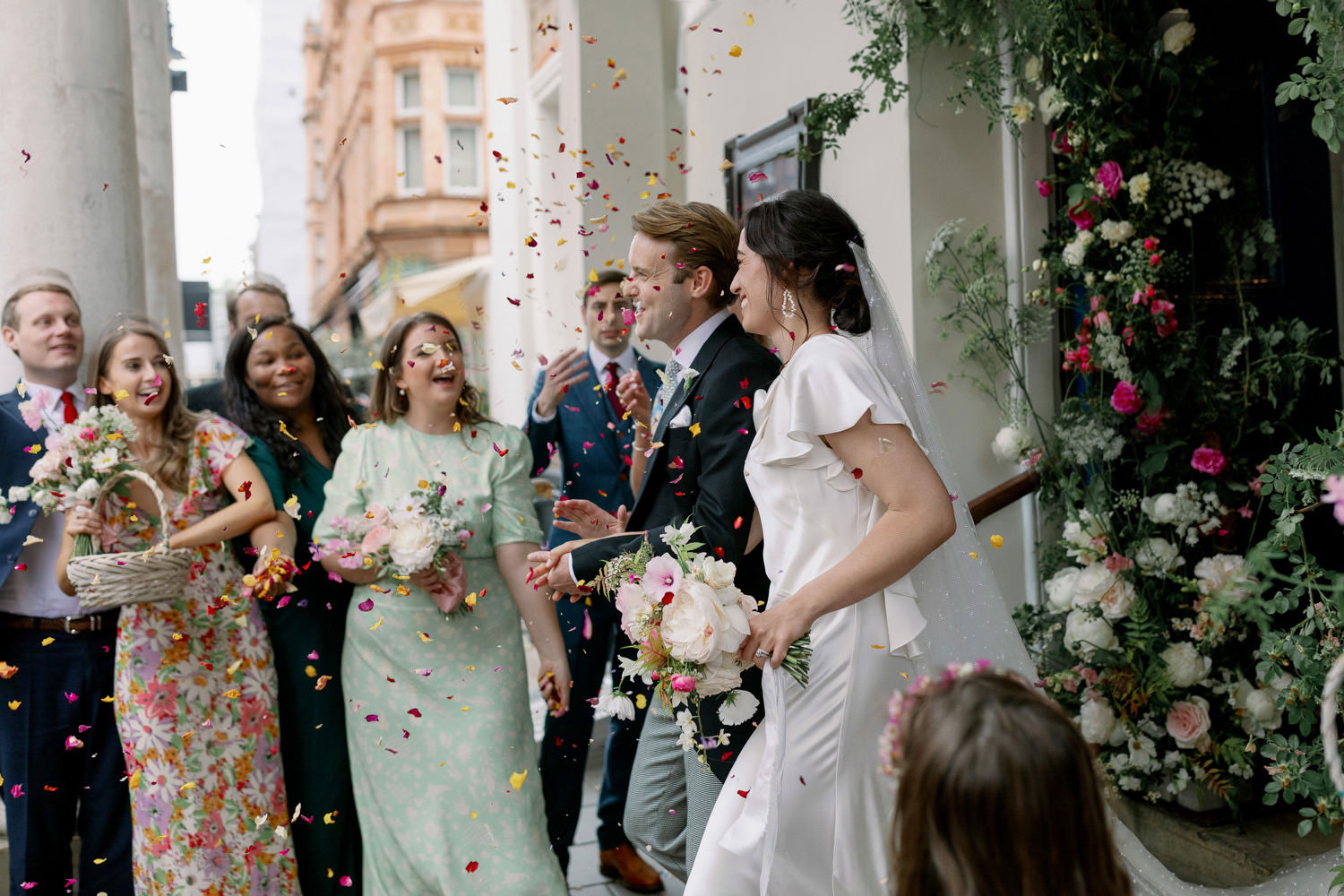 confetti being thrown over a smiling bride and groom